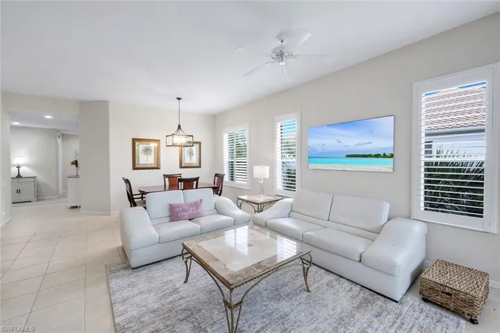 Living area featuring a ceiling fan and light tile patterned floors