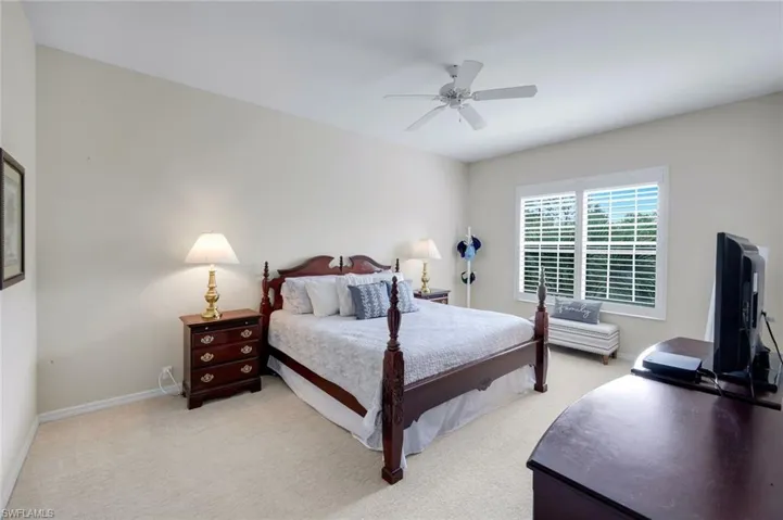 Bedroom with light carpet and a ceiling fan