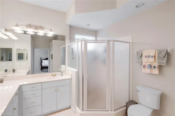 Bathroom with vanity, a stall shower, ensuite bath, and light tile patterned floors