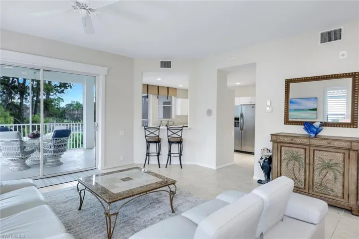 Living area featuring a ceiling fan and light tile patterned floors