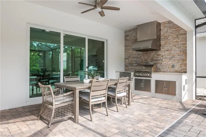 View of patio featuring area for grilling, a ceiling fan, and outdoor dining space