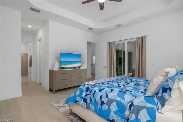 Bedroom with access to outside, a raised ceiling, and ceiling fan