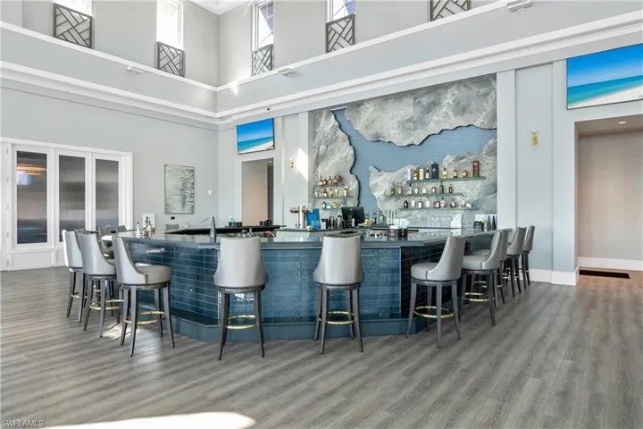 Indoor wet bar with wood finished floors and a towering ceiling