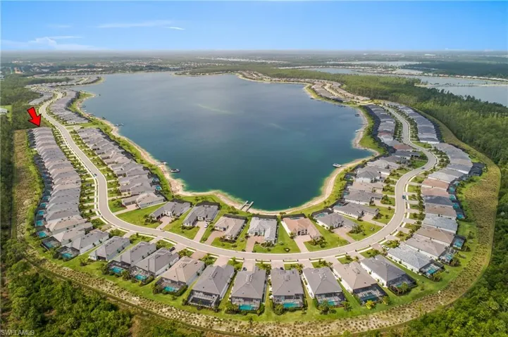 Aerial perspective of suburban area featuring a nearby body of water