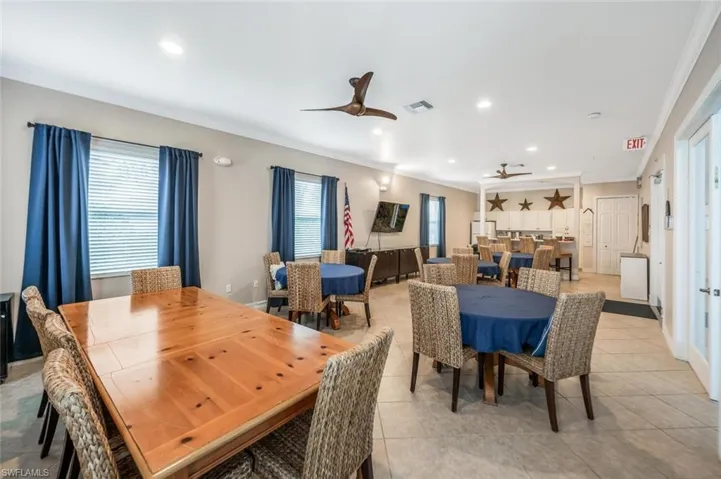 Community Tiled dining area with ceiling fan, a wealth of natural light, and crown molding