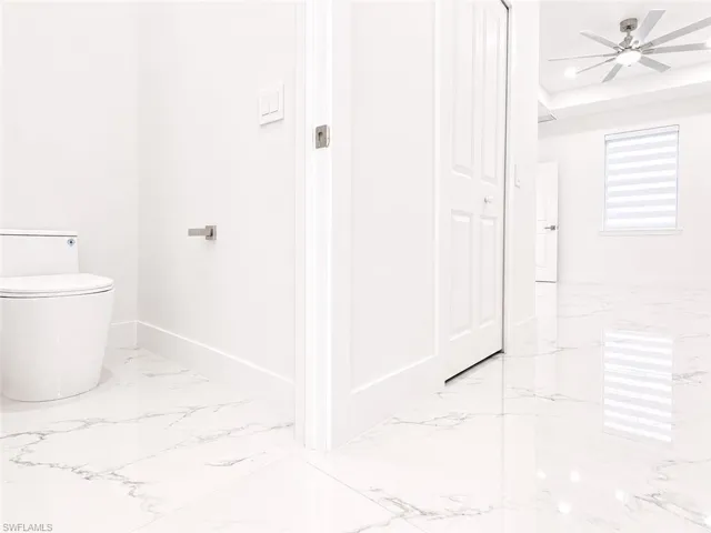 High-gloss marble-look tile flooring extends throughout, complemented by crisp white baseboards and walls