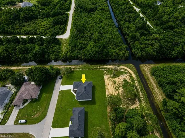 Aerial depiction of a property featuring a dark-tiled roof and a light-colored driveway