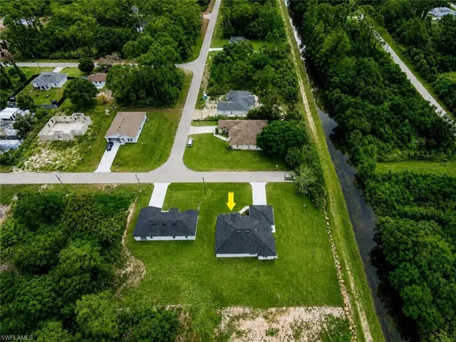Aerial perspective highlighting property with expansive green lawn and mature trees