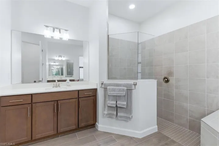 Double vanities and a tiled walk-in shower