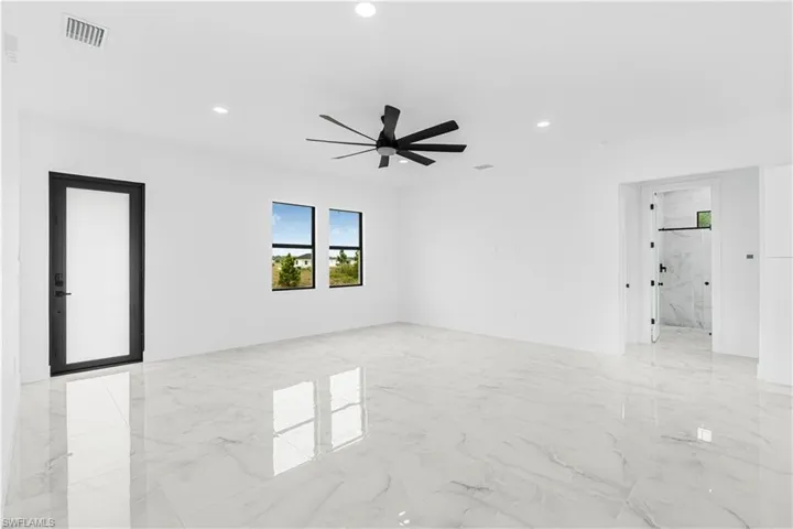 Spare room featuring marble finish floor, visible vents, and a ceiling fan