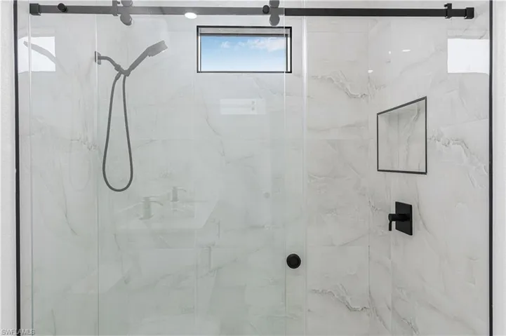 Full bathroom with a marble finish shower