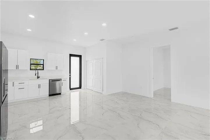 Kitchen with light countertops, a sink, dishwasher, marble finish floor, and visible vents