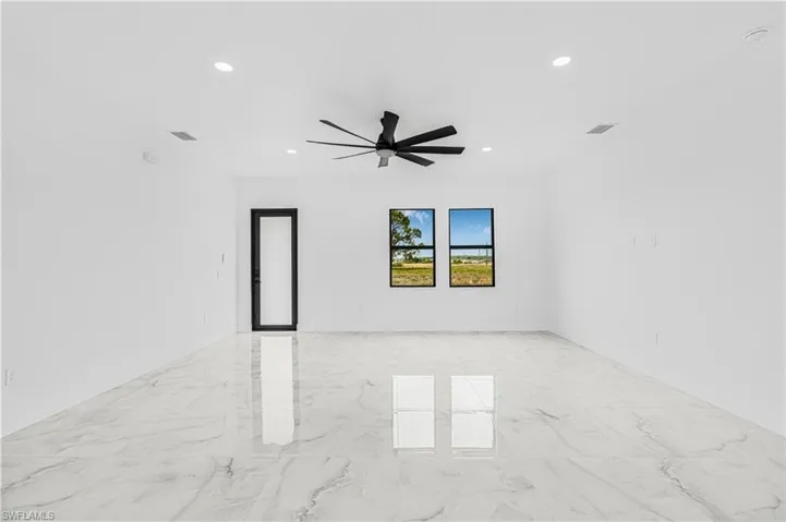 Empty room with marble finish floor, recessed lighting, visible vents, and ceiling fan