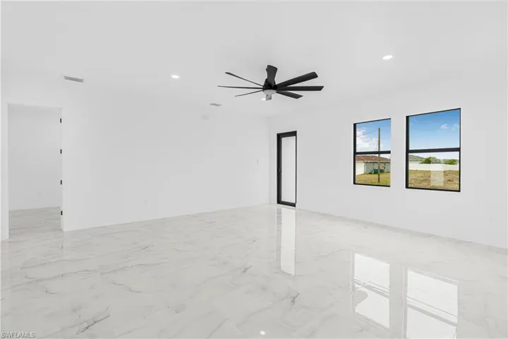 Empty room with marble finish floor, recessed lighting, visible vents, and ceiling fan