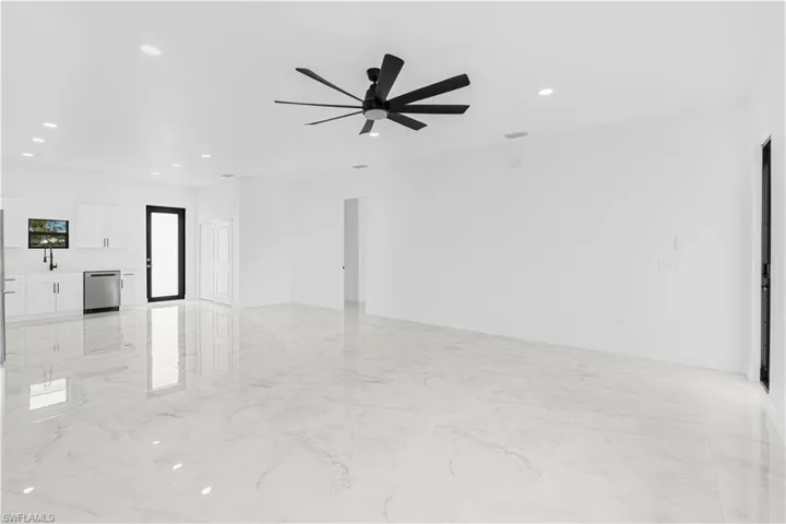 Unfurnished living room featuring marble finish floor, recessed lighting, a sink, and ceiling fan