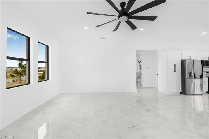 Spare room featuring marble finish floor, ceiling fan, and recessed lighting