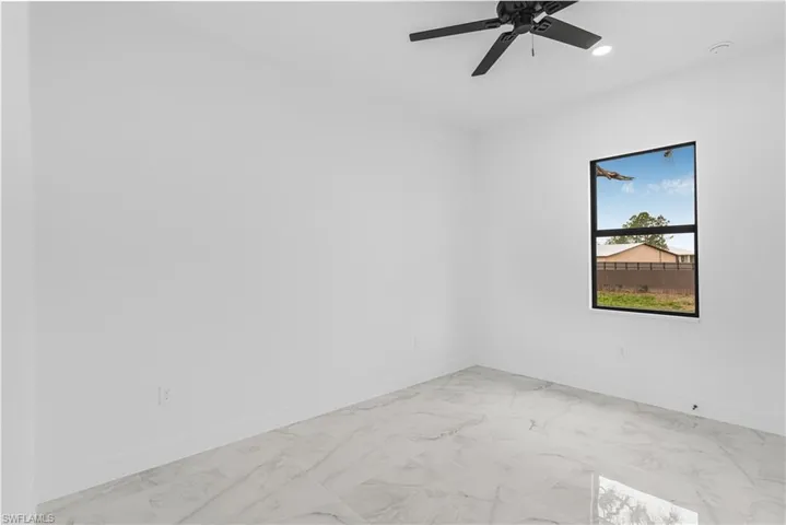 Empty room featuring baseboards, marble finish floor, ceiling fan, and recessed lighting