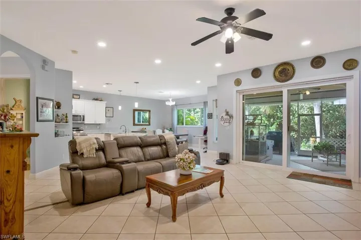 Living room with light tile patterned flooring, sink, and ceiling fan