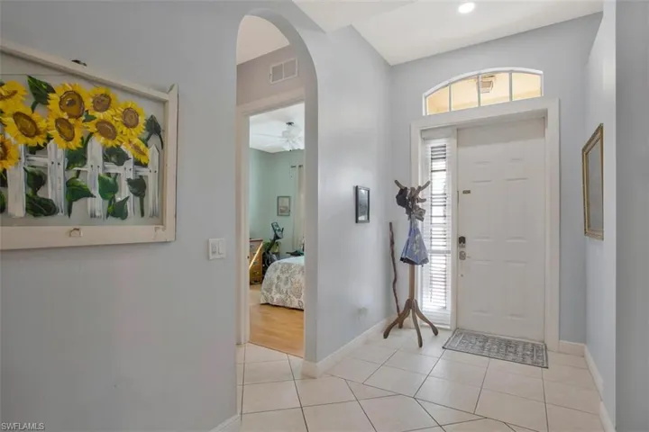 Foyer entrance featuring light tile patterned flooring and ceiling fan