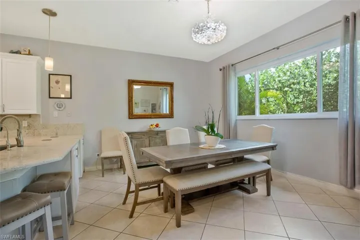 Dining area featuring sink, light tile patterned floors, and an inviting chandelier