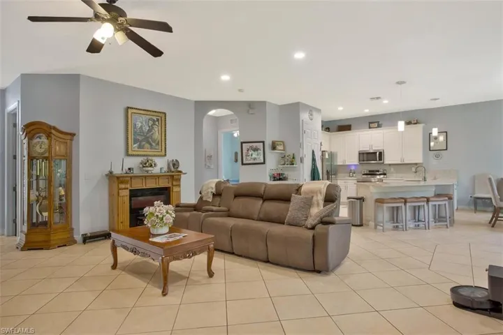 Tiled living room with ceiling fan and sink