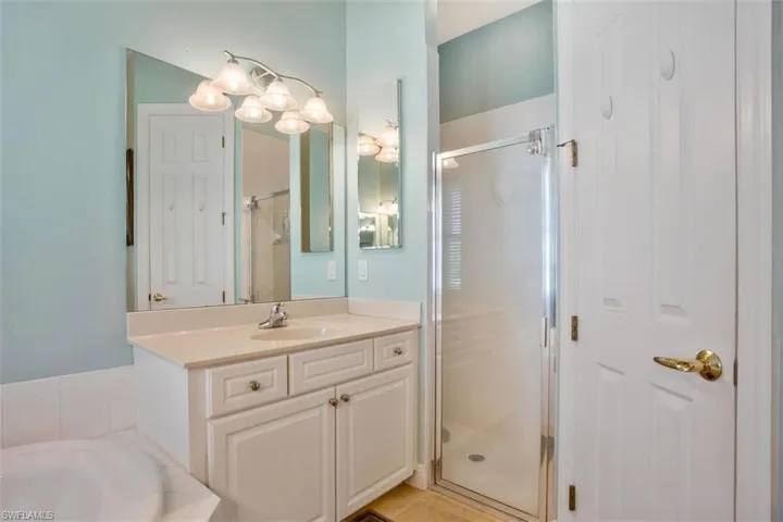 Bathroom with vanity, tile patterned floors, and plus walk in shower