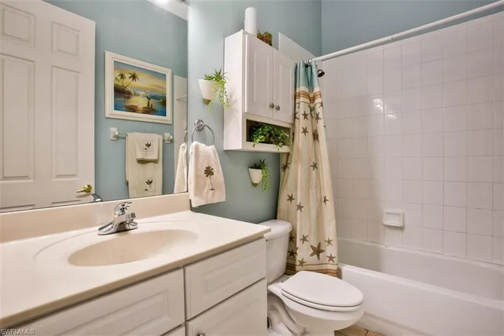 Full bathroom with vanity, toilet, and shower / bath combo with shower curtain
