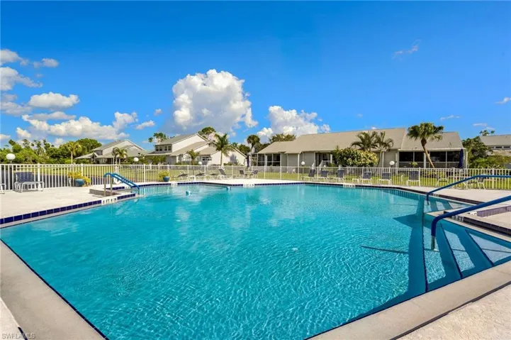 Community pool with a patio area and a residential view