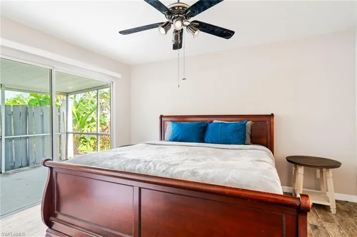Bedroom with wood finished floors, access to outside, and a ceiling fan
