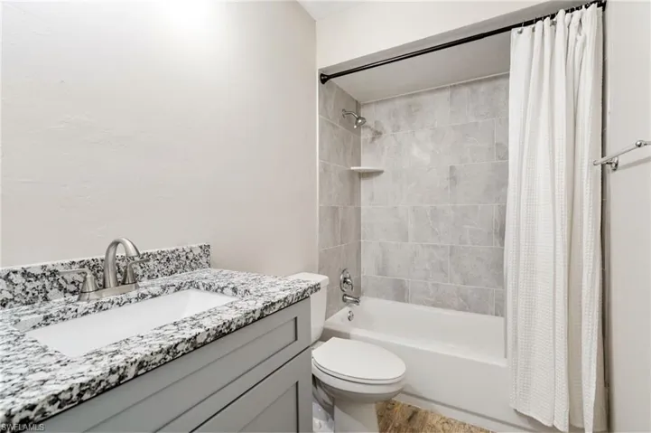 Bathroom featuring shower / bathtub combination with curtain and vanity