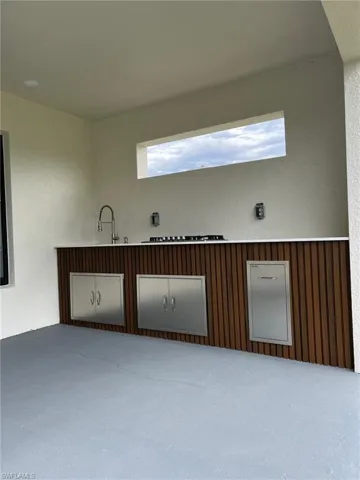 Unfurnished room featuring a sink and a textured wall