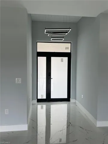 Unfurnished room featuring marble finish floor and baseboards