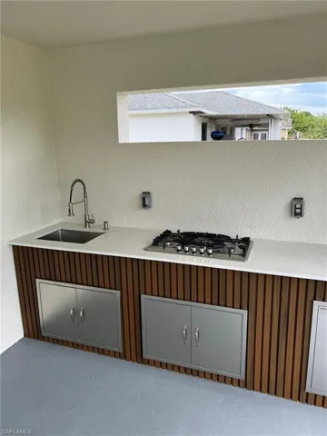 Kitchen featuring light countertops, a sink, and stainless steel gas stovetop