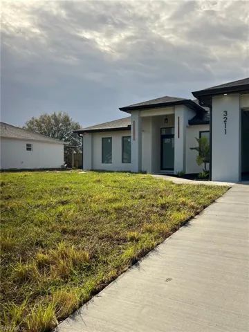 Prairie-style home featuring stucco siding and a front yard