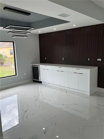 Bar featuring wine cooler, marble finish floor, and visible vents