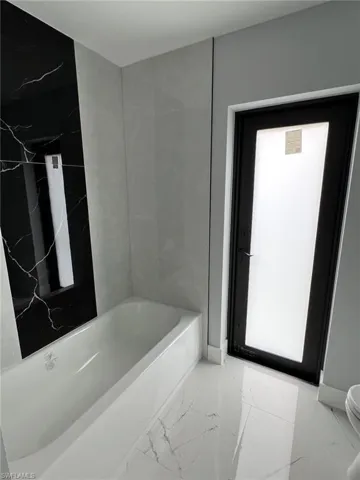 Bathroom with marble finish floor and toilet