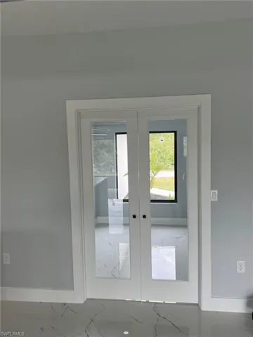 Doorway to outside with marble finish floor, baseboards, and french doors