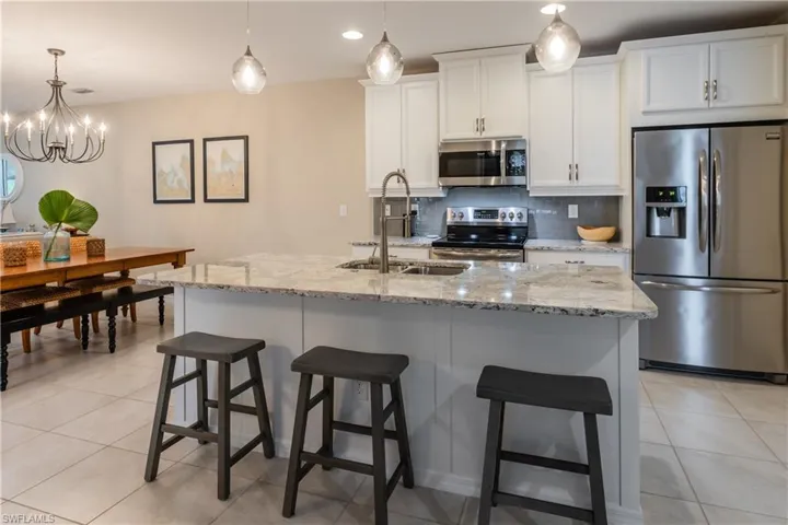 Kitchen with upgraded white cabinetry, quartz counter top on the island and board and batten detail
