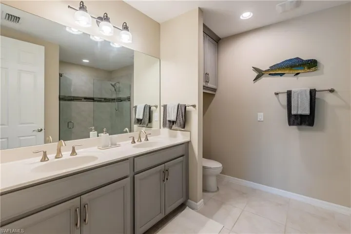 Ensuite primary bathroom offers dual sinks and extra upgraded cabinetry over the toilet