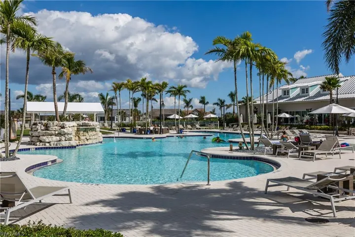 Large community swimming pool and deck with plenty of loungers