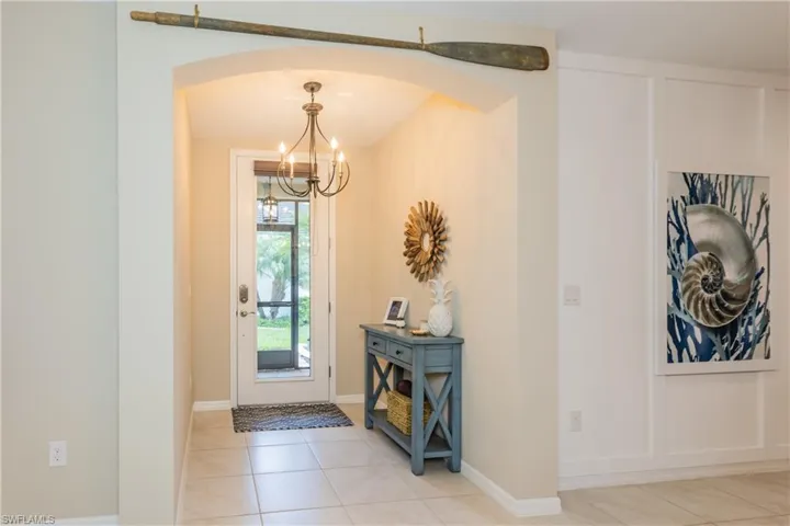 Elegant entrance foyer with upgraded light fixture and glass inset door and screened enclosure