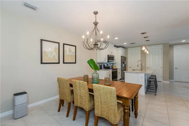Large Dining space featuring a high end chandelier and light tile floors