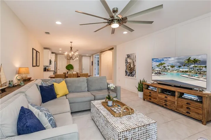 Living room featuring light tile floors throughout and large updated ceiling fan
