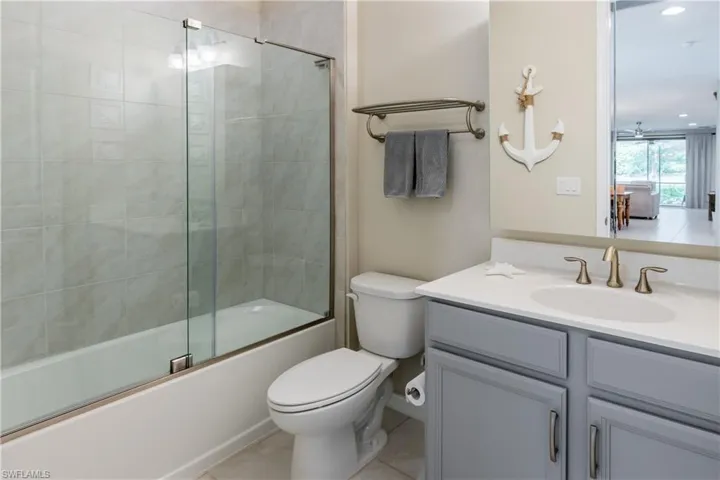 Guest bathroom updated with glass bathtub enclosure, updated cabinetry, medicine cabinet and lighting.