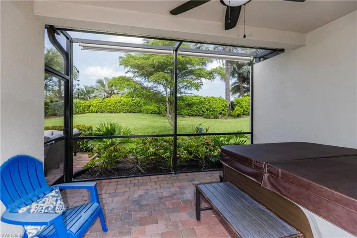 Covered paver Lanai featuring ceiling fan, sun shades and beautiful tropical landscaping
