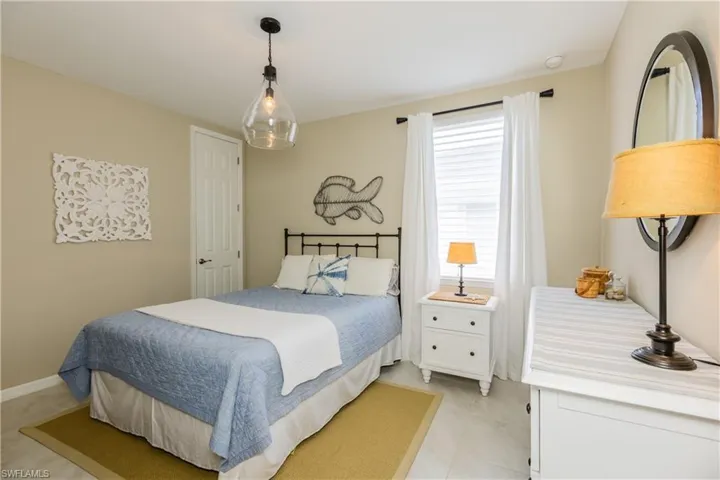 Guest bedroom with large closet, updated light fixture, remote control window treatments and tile floors