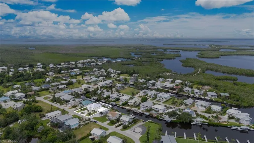 Aerial view of property's location with a nearby body of water and nearby suburban area