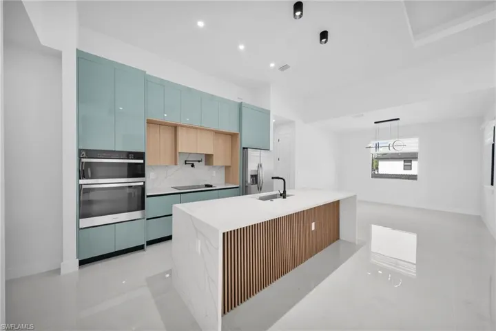 Kitchen featuring light stone counters, stainless steel appliances, tasteful backsplash, modern cabinets, and recessed lighting