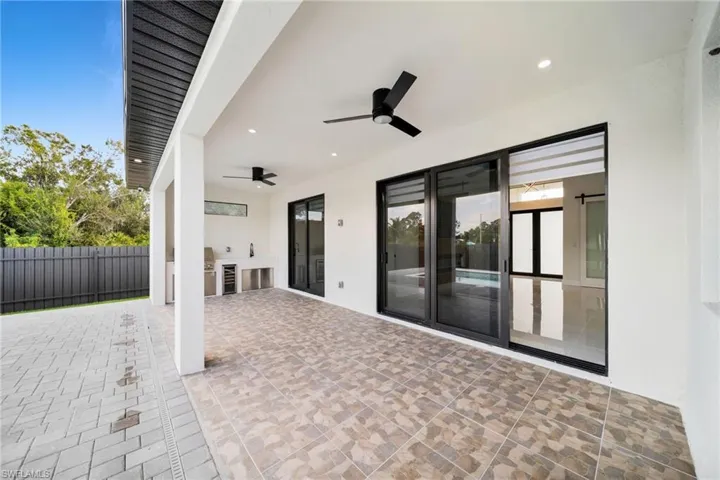 View of patio / terrace featuring exterior kitchen, ceiling fan, and wine cooler