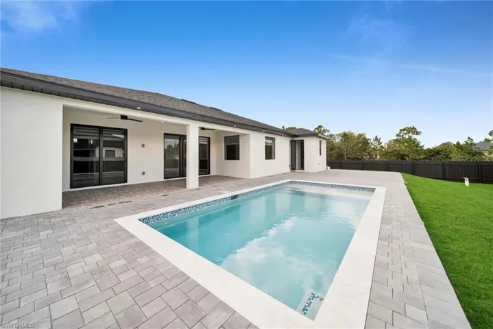 View of pool featuring ceiling fan, a patio area, and a fenced backyard
